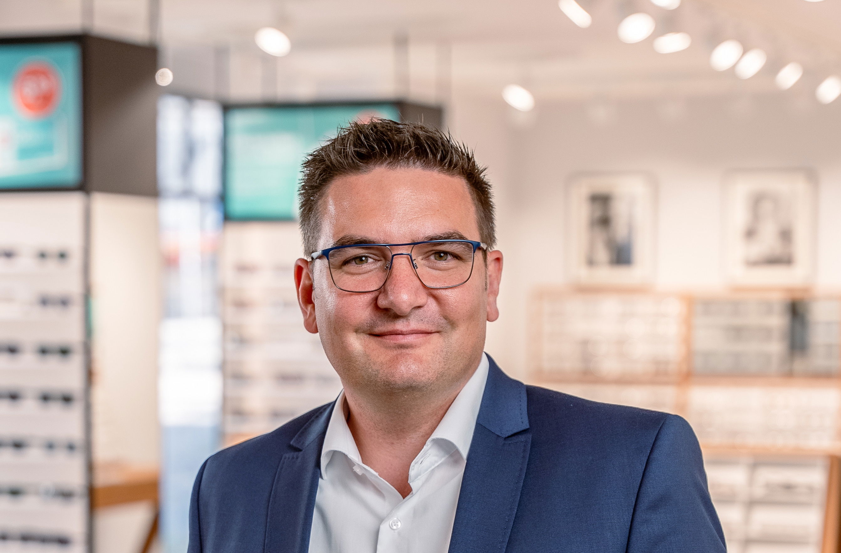 Jetzt als Anwendungsentwickler bei Abele Optik bewerben. Das Bild zeigt einen Mitarbeiter in blauem Sakko in Nahaufnahme.